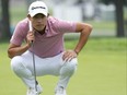 Collin Morikawa of the United States lines up a putt on the 13th green during the first round of the Rocket Mortgage Classic.